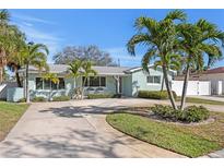 Charming single-story home featuring a well-manicured lawn, palm trees, and a spacious driveway at 1003 39Th Ne Ave, St Petersburg, FL 33703