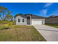 Charming single-story home with a two-car garage and well-maintained lawn at 122 Jennifer Dr, Rotonda West, FL 33947
