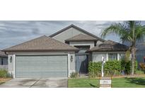 Charming single-Gathering home featuring a two-car garage, well-maintained lawn, and mature landscaping at 6024 162Nd E Ave, Parrish, FL 34219