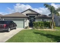 Charming single-story home with a well-manicured lawn, lush landscaping, and a two-car garage at 6024 162Nd E Ave, Parrish, FL 34219
