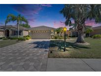 Charming single-story home boasts lush landscaping, a paver driveway, and a two-car garage at 830 Regal Manor Way # 1, Sun City Center, FL 33573