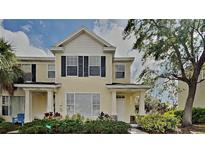 Charming two-story townhouse with a yellow facade and well-maintained landscaping at 12426 Country White Cir, Tampa, FL 33635