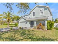 Charming two-story home with a manicured lawn, mature trees, and an attached two-car garage at 2944 Billingham Dr, Land O Lakes, FL 34639