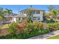 Charming two-story home featuring lush landscaping, a wooden fence, and a well-maintained lawn at 330 42Nd S Ave, St Petersburg, FL 33705