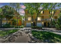 Inviting two-story townhome with an attached one-car garage, balcony, and lush landscaping at 5014 W Lancaster St, Tampa, FL 33616