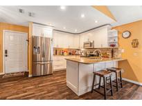 Well-lit kitchen featuring white cabinetry, stainless steel appliances, and wood flooring at 6262 142Nd N Ave # 904, Clearwater, FL 33760