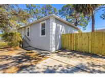 Charming gray home featuring a new, natural wood fence with a spacious driveway at 750 E Harbor S Dr, St Petersburg, FL 33705