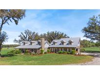 Stunning two-story home featuring metal roof, manicured lawn, and mature trees offering shade and privacy at 808 Old Welcome Rd, Lithia, FL 33547