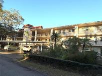 A three-story condo building with covered parking and landscaping features inviting balconies at 865 Virginia Ct # 106, Dunedin, FL 34698