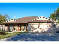 Charming single-story home featuring a well-maintained front yard and welcoming entrance with a red door at 9643 Temple Ave, Seminole, FL 33772