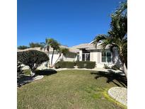 Charming single-story home with lush lawn, tropical landscaping, and decorative rock features at 2021 E Del Webb Blvd, Sun City Center, FL 33573