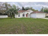 Charming single Gathering home features a manicured lawn and attached two car garage at 3292 Dow Ln, Spring Hill, FL 34609