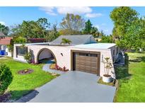 Charming single-story home with a gray driveway and a well-manicured front lawn at 3455 Overland Dr, Holiday, FL 34691