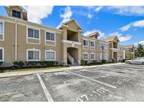 Beige two-story condo building with multiple units and visible parking spots at 6447 Cypressdale Dr # 202, Riverview, FL 33578