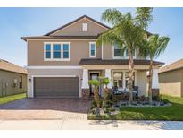 Inviting two-story home with lush landscaping and covered front porch, perfect for enjoying the outdoors at 8766 Capstone Ranch Dr, New Port Richey, FL 34655