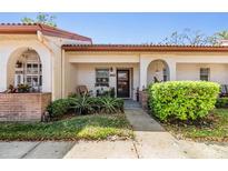 Charming front entrance with cozy seating and a well-maintained walkway with green shrubs at 1159 Montrose Pl, Dunedin, FL 34698