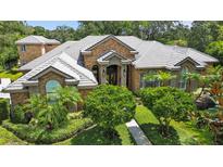 Stunning brick home featuring lush landscaping, manicured bushes, and a tiled roof at 16211 Villarreal De Avila, Tampa, FL 33613