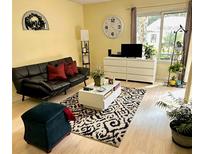 Bright living room features a black futon, patterned rug, and white furniture at 2205 Belleair Rd # A7, Clearwater, FL 33764