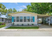 Charming single-story home with blue shutters, covered parking, and well-manicured landscaping at 238 Pelican N Dr, Oldsmar, FL 34677