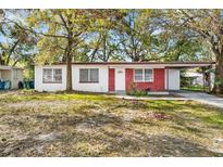 Charming single-story home with red brick accents, a covered parking area, and a well-maintained front yard at 3005 E Sligh Ave, Tampa, FL 33610