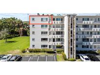 Multi-story building with balconies, stone accents, and well-maintained landscaping near a parking area at 4210 Ironwood Cir # 501J, Bradenton, FL 34209