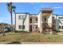 Two-story condo building featuring stucco walls, brown trim, and well-maintained landscaping at 7701 Starkey Rd # 526, Seminole, FL 33777