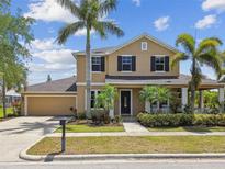 Charming two-story home featuring lush landscaping, a two-car garage, and a welcoming front porch at 824 Islebay Dr, Apollo Beach, FL 33572