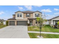 Charming two-story home boasts a two-car garage, well-maintained lawn, and welcoming curb appeal at 13549 Willow Bluestar Loop, Riverview, FL 33579