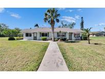 Charming single-story home with a well-maintained lawn, mature landscaping, and a welcoming walkway leading to the front door at 1902 Dandridge St # 6, Sun City Center, FL 33573