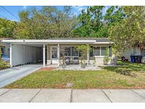 Charming single-story home featuring a carport, neutral paint scheme, and inviting landscaping at 427 5Th Nw St, Largo, FL 33770