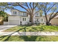 Charming two-story home with mature trees, beautiful landscaping, and a two-car garage at 4614 W Lowell Ave, Tampa, FL 33629