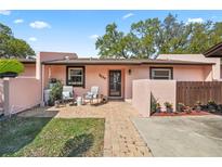 Charming front exterior with a brick path, cozy seating area, and well-maintained landscaping at 7239 55Th N Ave, St Petersburg, FL 33709