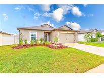 Charming single-story home with a well-maintained lawn, mulch beds, and a two car attached garage at 12960 Conquistador Loop, Spring Hill, FL 34610