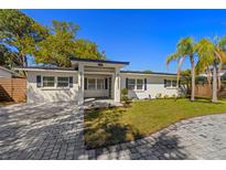 Charming single-story home with freshly painted exterior, manicured lawn and stone paver driveway at 2117 S West Shore Blvd, Tampa, FL 33629