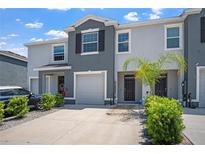 A modern two-story townhome shows a well-maintained lawn, an attached single car garage, and neutral color palette at 2892 Beluga Bay Dr, Odessa, FL 33556
