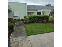 Inviting front yard with lush green landscaping and walkway leading to the home's entrance at 3902 Trophy Blvd, New Port Richey, FL 34655