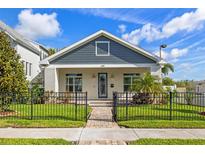Charming home featuring stylish curb appeal, complemented by a lush lawn and decorative black metal fence at 445 29Th N Ave, St Petersburg, FL 33704