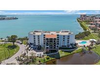 Waterfront condo with community pool, pond, bay views, and palm tree landscaping at 5700 Escondida S Blvd # 506, St Petersburg, FL 33715