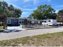 Charming single-story home features a well-manicured lawn, picket fence, and a paved driveway at 126 E Center St, Tarpon Springs, FL 34689