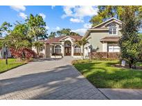 Elegant home with stone accents, arched windows, and a lush front yard at 2309 Valrico Forest Dr, Valrico, FL 33594
