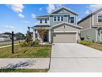 Charming two-story home featuring a well-manicured lawn and a spacious two-car garage at 28889 Orange Berry # Dr, Wesley Chapel, FL 33543