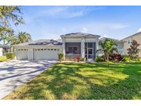 Well-maintained, one-story home with a three-car garage, screened porch, and a lush green lawn at 3629 Mossy Oak Cir, Land O Lakes, FL 34639