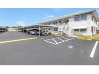 Exterior of condo building with parking lot including covered parking spaces for residents and guests at 5347 81St N Ln # 25, St Petersburg, FL 33709