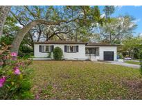 Charming single-story home boasts a well-maintained yard, mature tree, and classic architectural details at 803 S Evergreen Ave, Clearwater, FL 33756