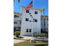 Condominium building exterior with an American flag, lush landscaping and impact windows at 8402 111Th St # 303, Seminole, FL 33772