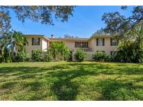 Charming two-story home with lush green lawn and mature landscaping at 11327 Carter Grove Ln, Thonotosassa, FL 33592