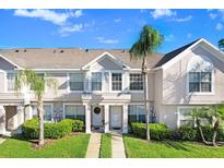 Charming townhouse exterior featuring a well-manicured lawn, and neutral colors, providing a welcoming curb appeal at 435 Kensington Lake Crk, Brandon, FL 33511