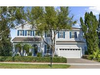 Charming two-story home with blue shutters, landscaped yard, and attached two-car garage at 5305 Sagecrest Dr, Lithia, FL 33547