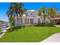 Elegant two-story home with a manicured lawn, beautiful landscaping, and a covered porch with classic white columns at 708 Islebay Dr, Apollo Beach, FL 33572