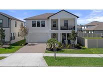Beautiful two-story home featuring a balcony, a well-manicured lawn, and a brick driveway at 9817 Coneflower Ct, Land O Lakes, FL 34637